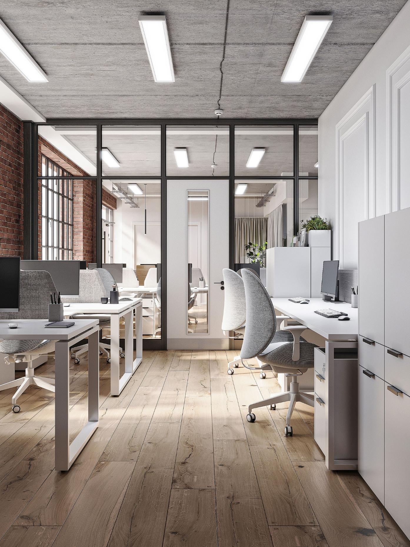 Workstation row with Crittall glass partition and exposed brick wall beyond