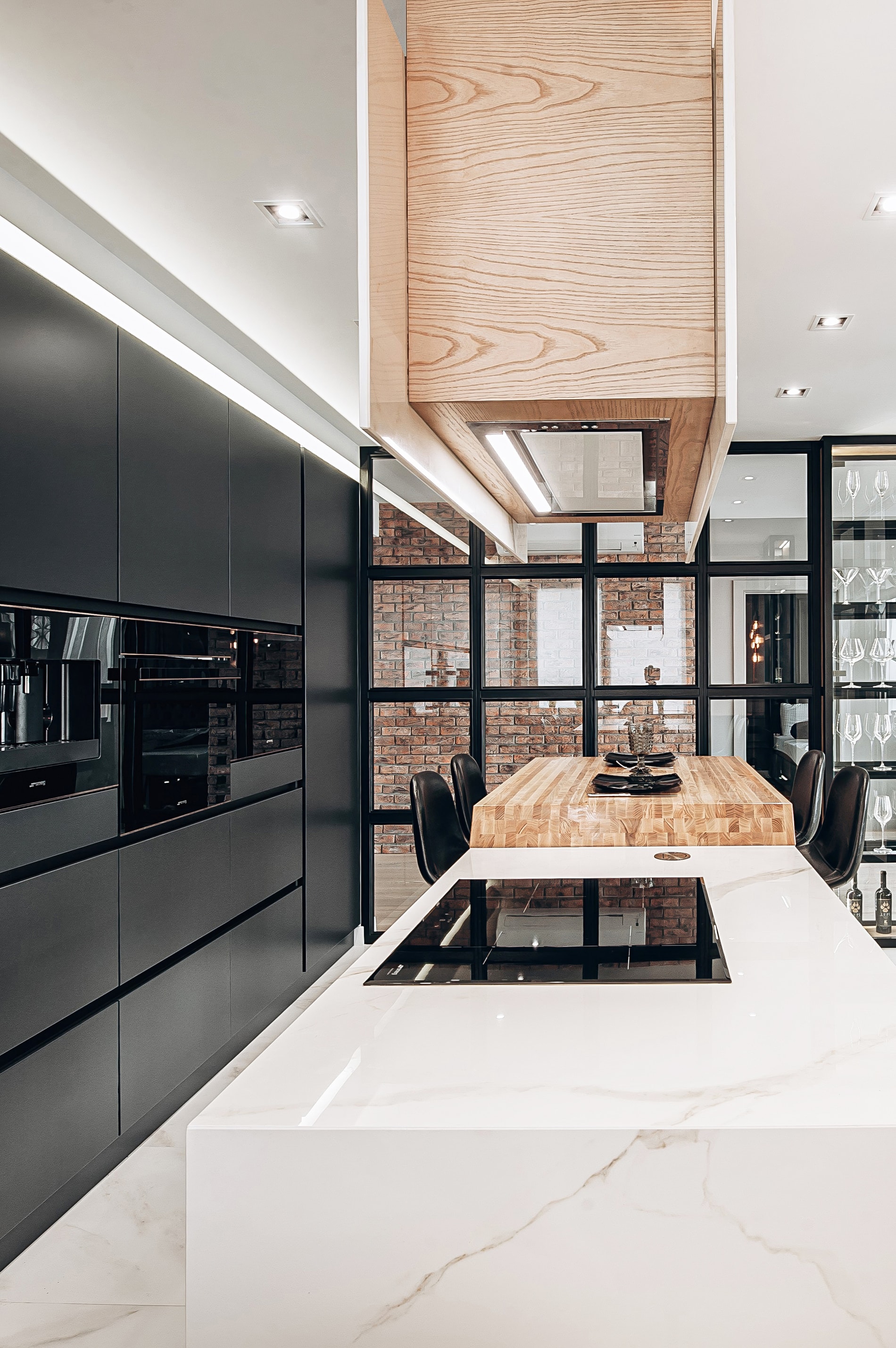 Kitchen space with an oak extractor, marble island and dining table