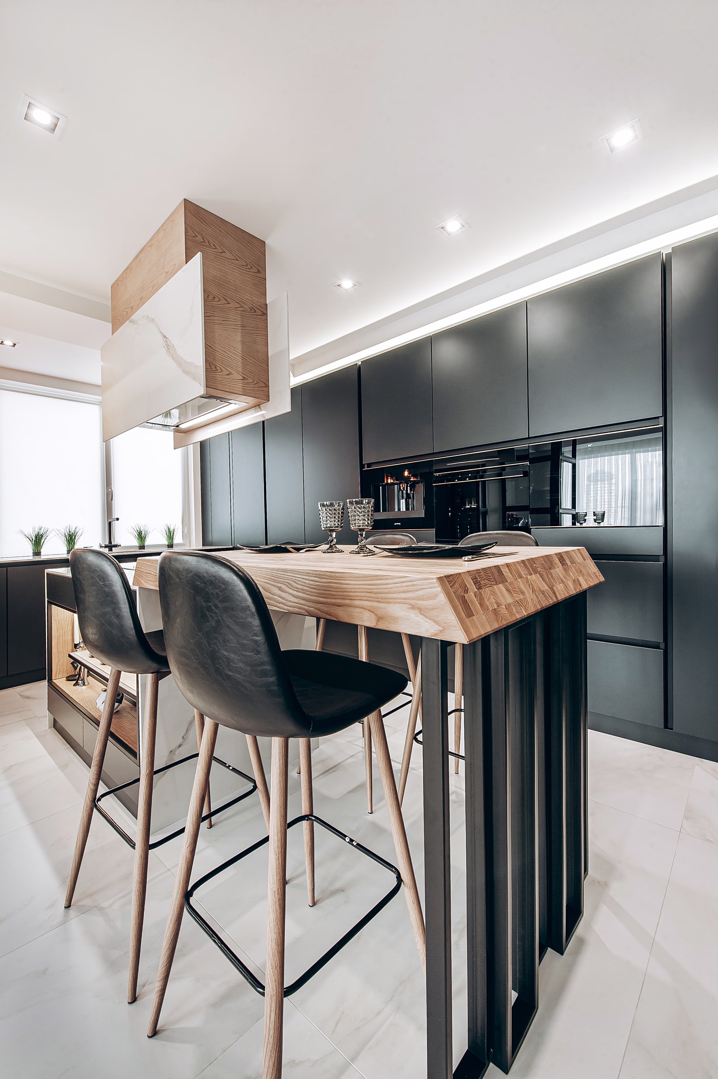 Extractor in an oak housing with a marble panel above the oak breakfast bar