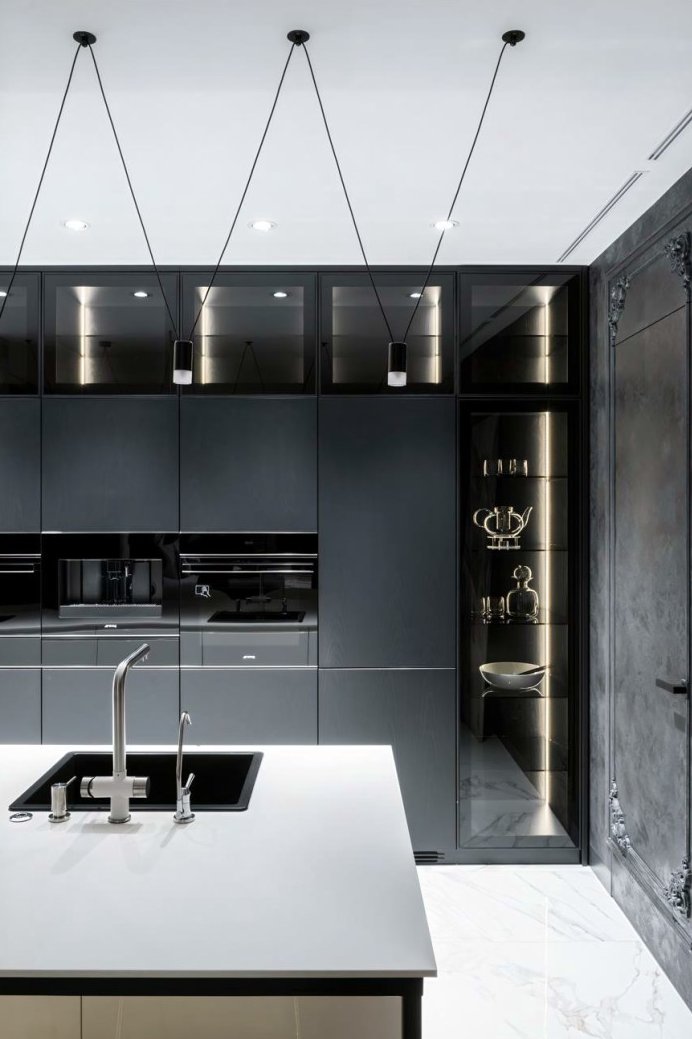 Tall bespoke cabinetry with integrated appliances and brushed brass detailing