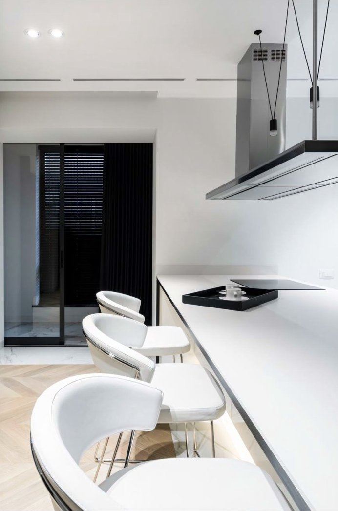 Kitchen island with quartz worktop, oak bar stools and pendant lights above