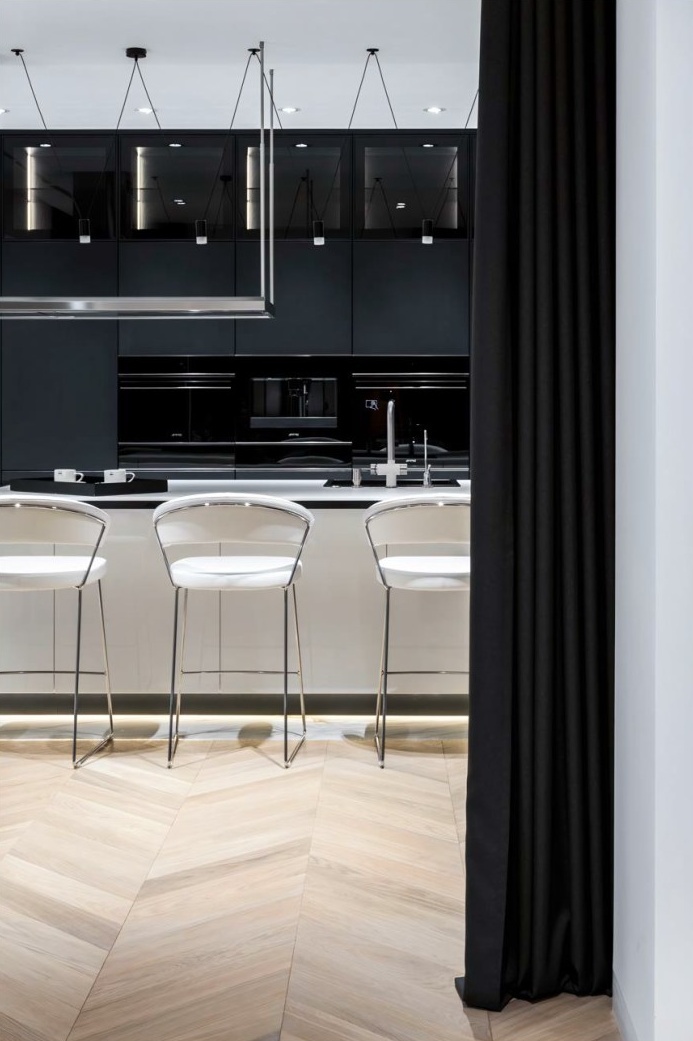 Close detail of a brushed brass tap and honed stone worktop against dark cabinetry