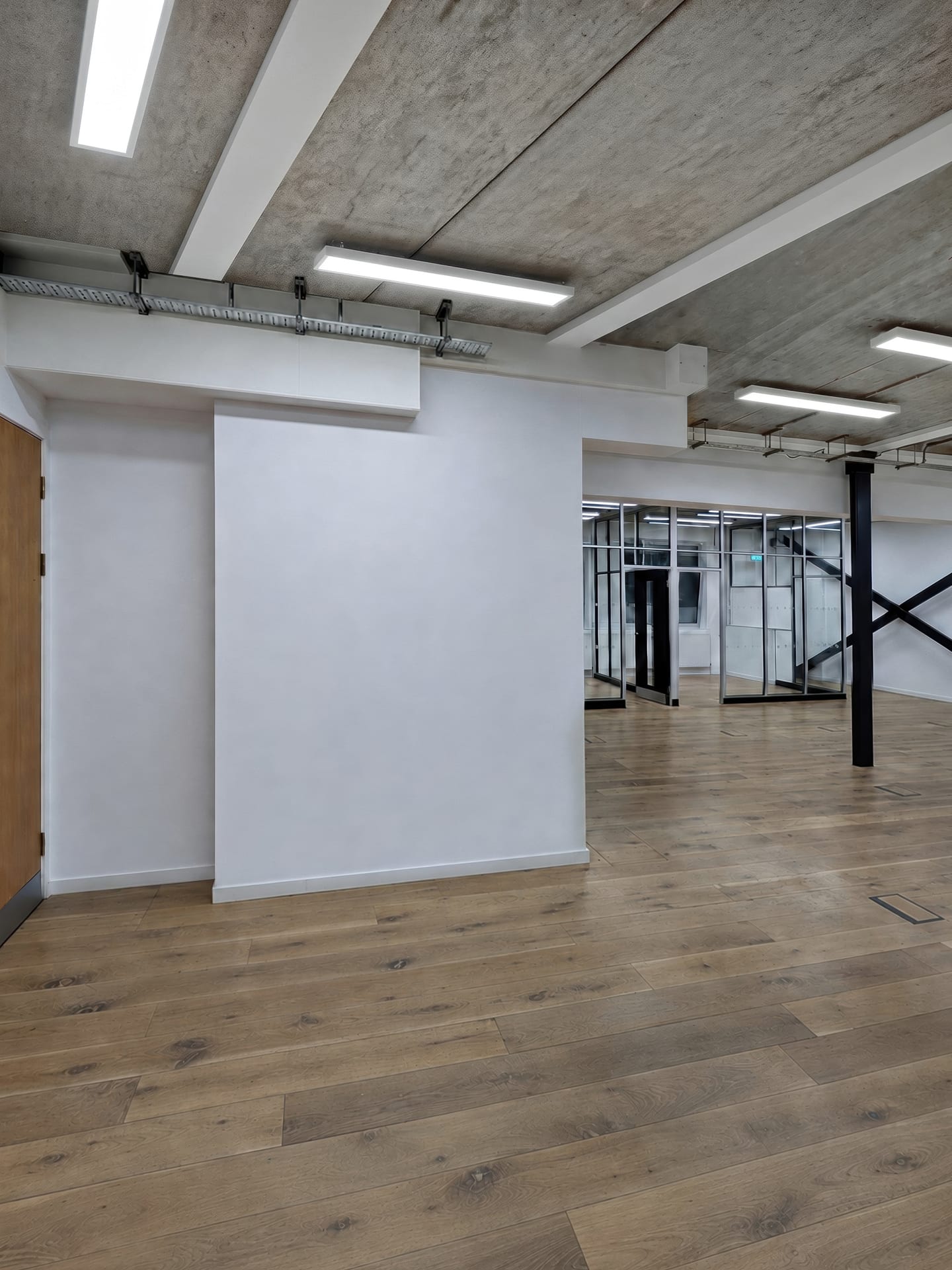 Office space before the fit-out: bare walls and an exposed concrete ceiling